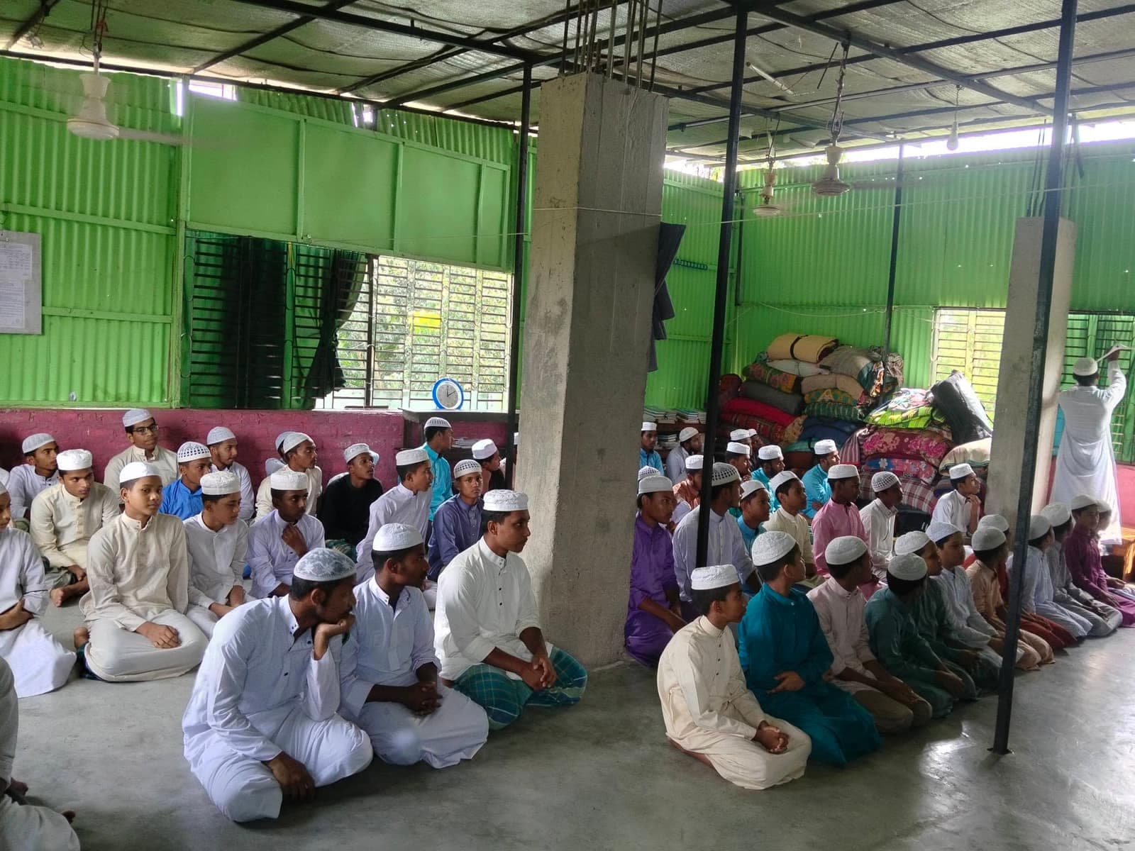 মাদরাসা হলে পাঠের জন্য একত্রে বসা শিক্ষার্থীরা