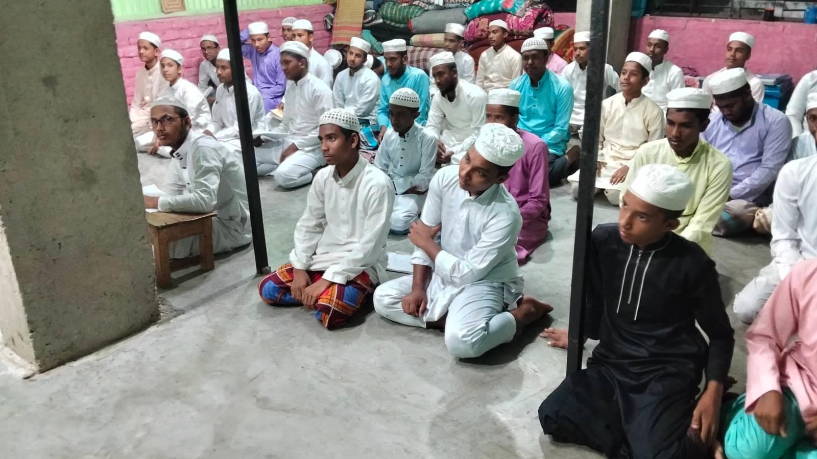 মাদরাসা হলে সমাবেশ চলাকালে মনোযোগী প্রবীণ শিক্ষার্থীরা
